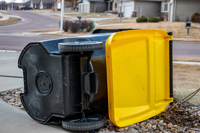 Garbage collection bin blown over by wind in residential area