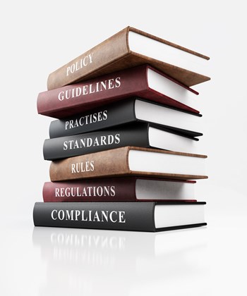 Leather covered book of compliance. Stack of books on top of each other with business words written on their spines. Isolated on white background with clipping path.