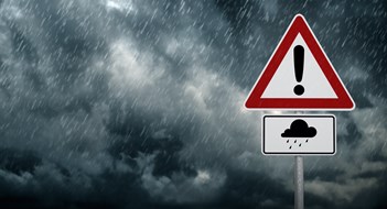 Protecting Your Condo or Co-op from the Next Major Storm A dark cloudy sky with rain and warning sign - computer generated image