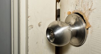 Q&A: Ardor Over Our Door Broken modern doorknob closeup with signs of forced entry, criminal activity and door slightly open.