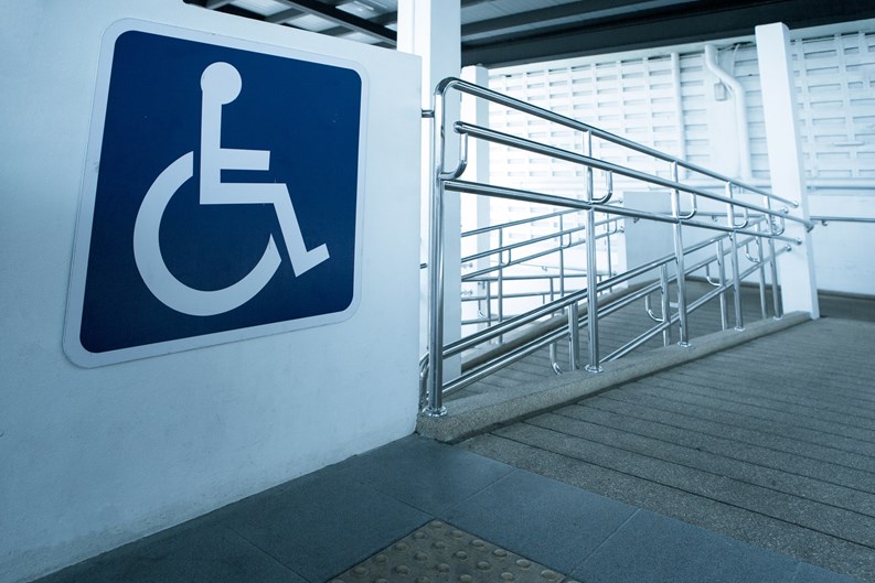 Concret ramp way with stainless steel handrail with disabled sign for support wheelchair disabled people.