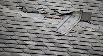 A badly damaged roof with missing shingles in need of repair