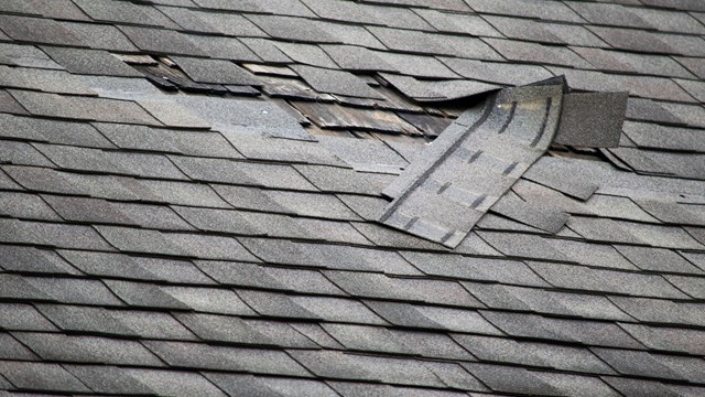 A badly damaged roof with missing shingles in need of repair