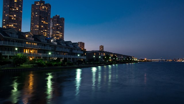 A view from a pier on the Hudson River of NJ illuminated at night