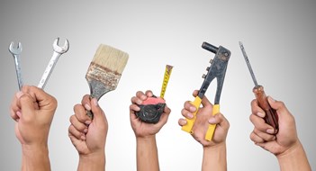 Hands holding different carpentry tools isolated on white background.