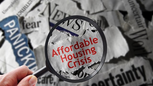 Affordable Housing Crisis newspaper headline and magnifying glass