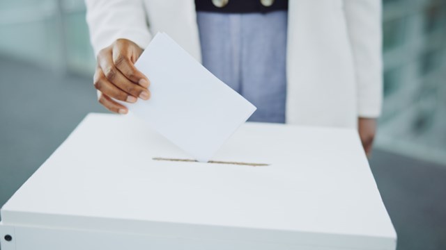 Hand, ballot and box for vote paper at president election cast, poll station choice or government selection. Person, fingers and decision document or politics support or usa process, opinion at booth