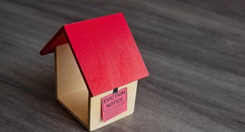 Evicting an Owner or Shareholder Closeup image of toy house and eviction notice.