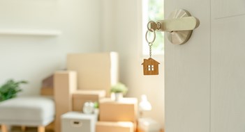 New Owner Challenges Moving house, relocation. The key was inserted into the door of the new house, inside the room was a cardboard box containing personal belongings and furniture. move in the apartment or condominium