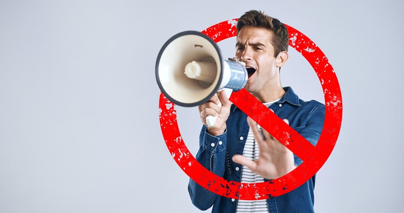 Megaphone, stop and man with protest, speech and justice on a white studio background. Person, model or activist with a bullhorn, rejection or graphic sign for warning, speaker for equality or change