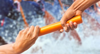 Board Continuity hands passing a relay baton on rowing team background and color tone effect.